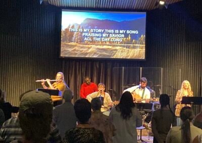 Margaret Graham leading a live worship session with a band and congregation.
