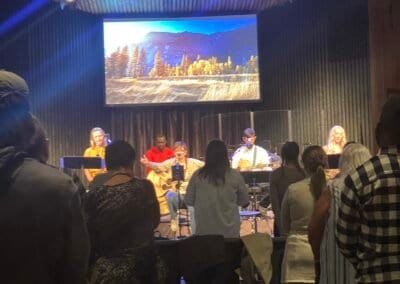 Audience watching panel discussion with scenic mountain backdrop.